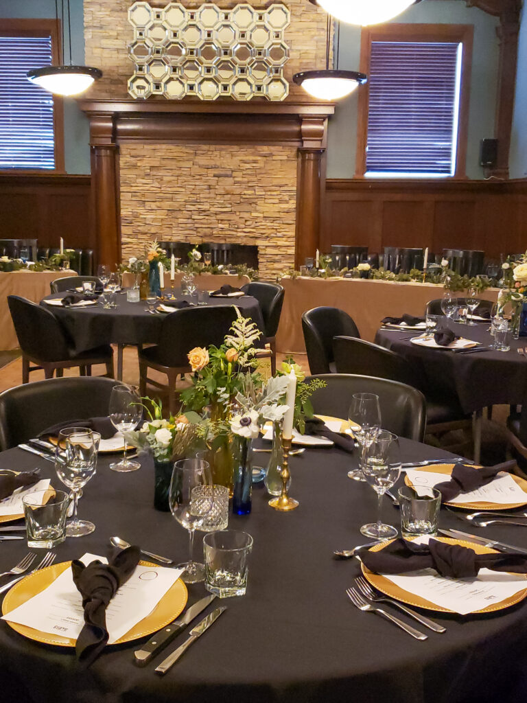 Photo of the main event room decorated in black and gold colors for a wedding.